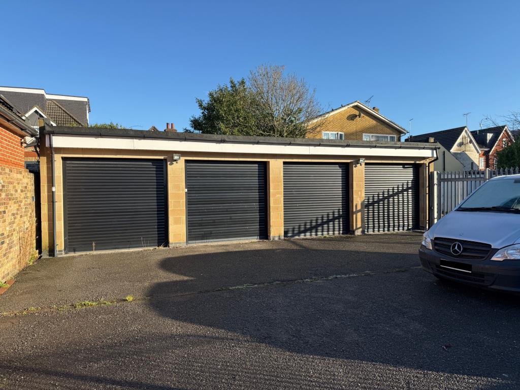 Lot: 78 - GARAGES AND FORECOURT WITH POTENTIAL - Four Garages with black roller shutter fronts